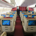 a inside of an airplane with rows of seats and monitors