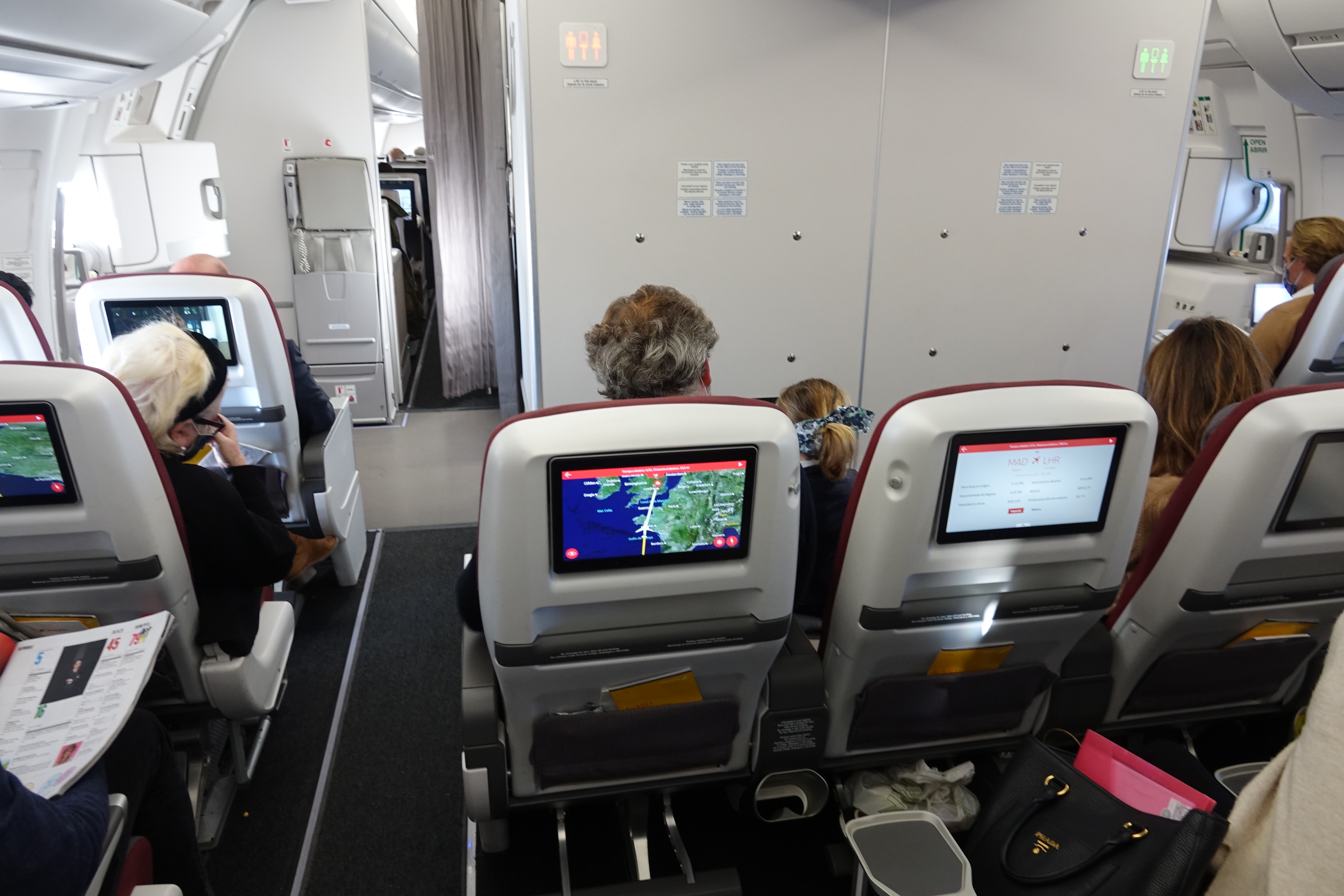 people sitting in an airplane with a screen on the back
