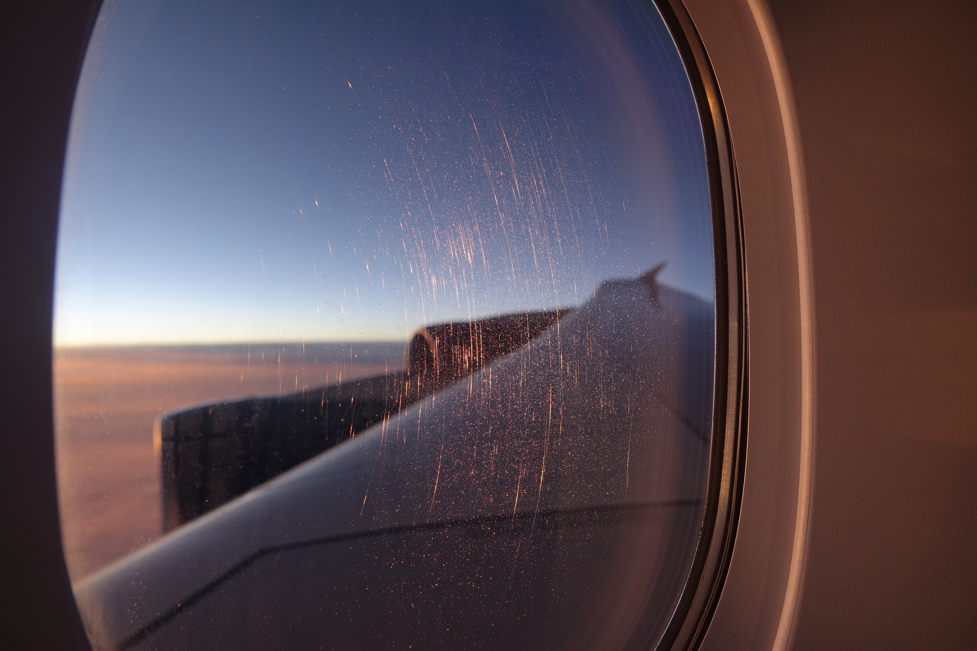 a window with a view of the wing of an airplane