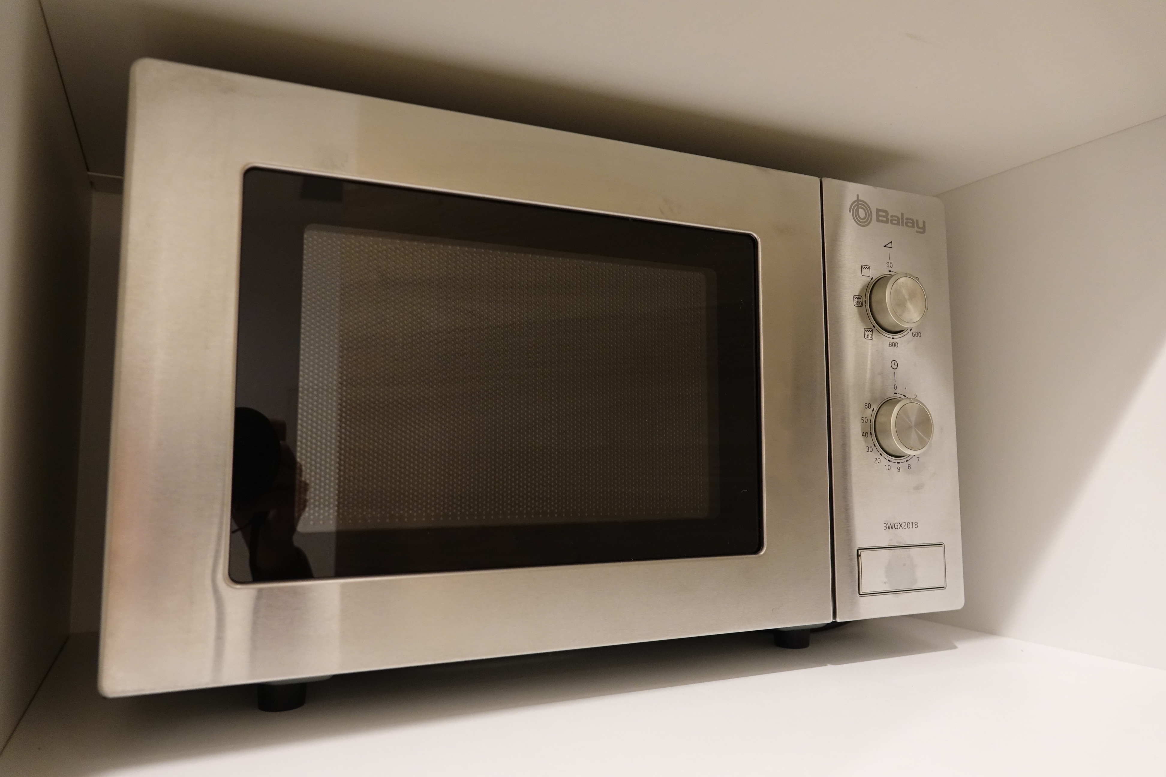 a silver microwave oven with knobs