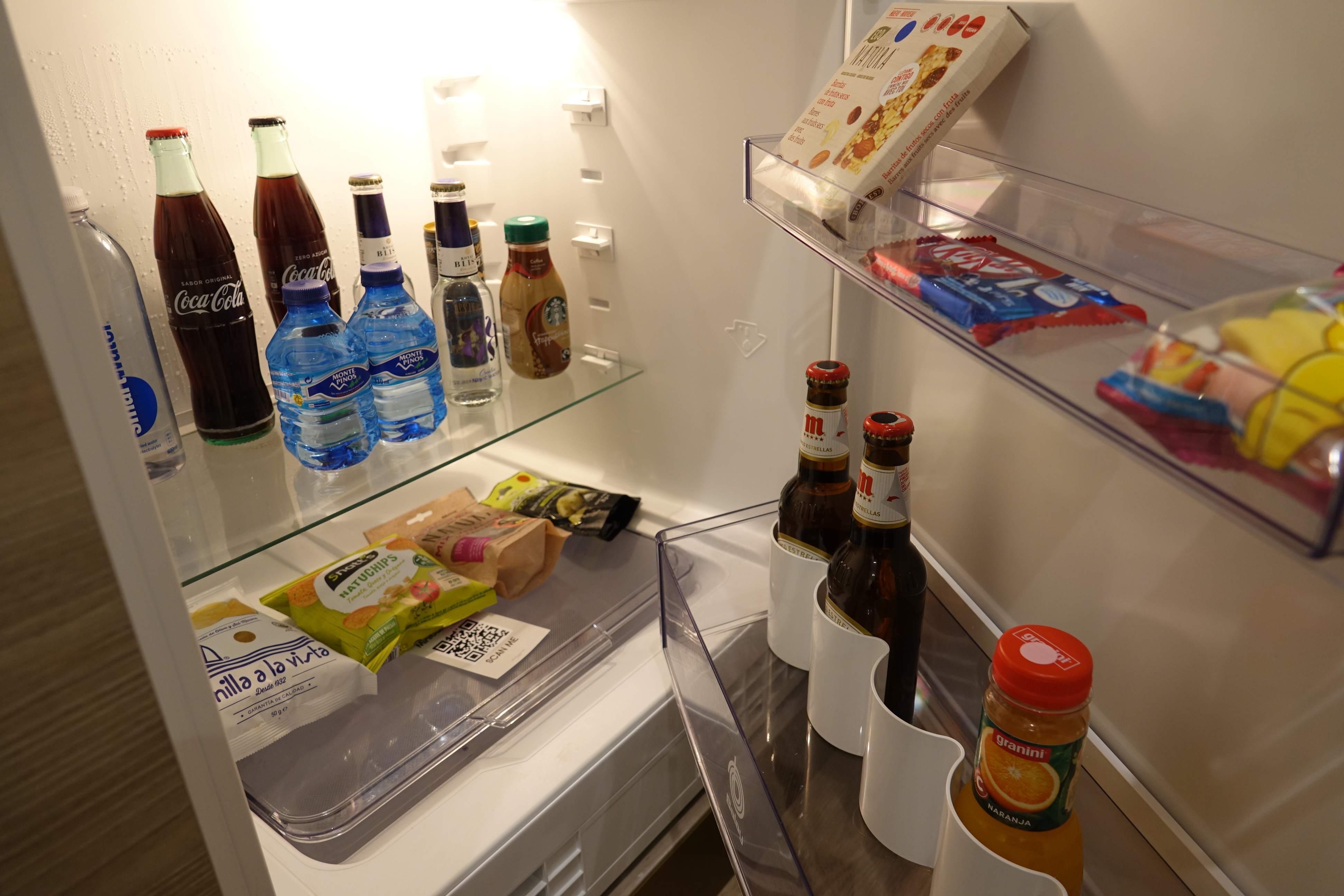 a refrigerator with bottles of food and snacks