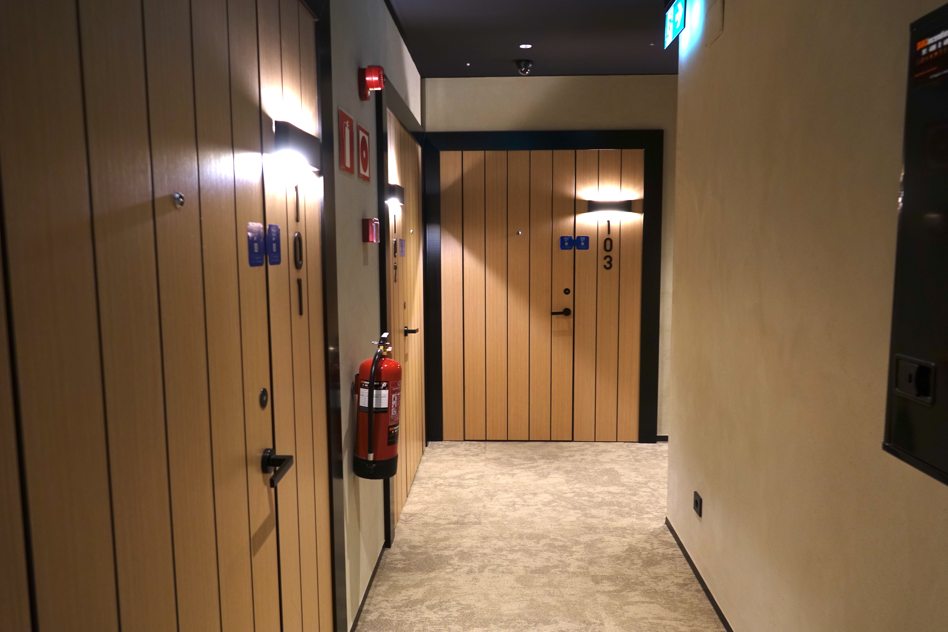 a hallway with doors and fire extinguisher