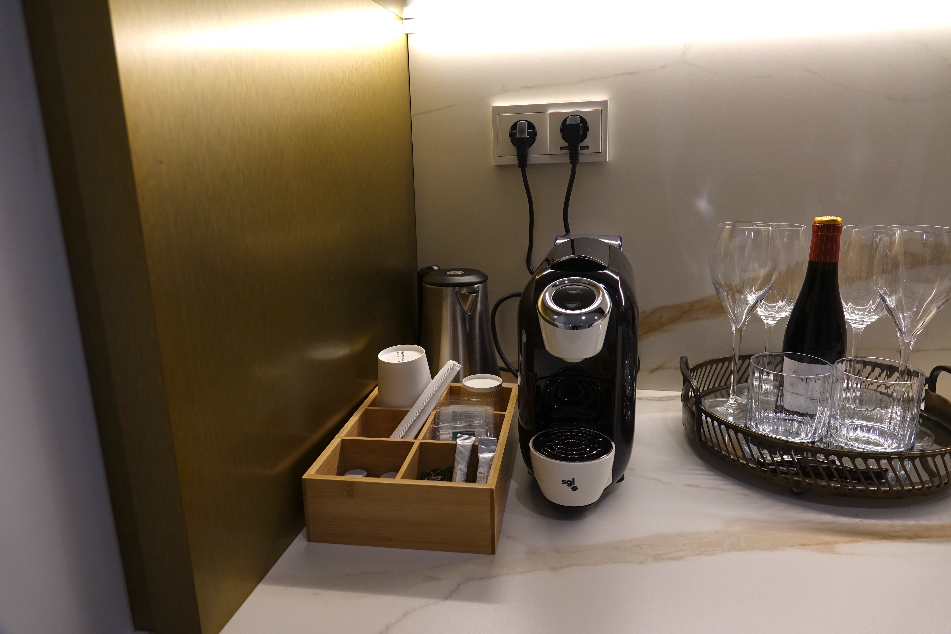 a coffee machine and wine glasses on a counter