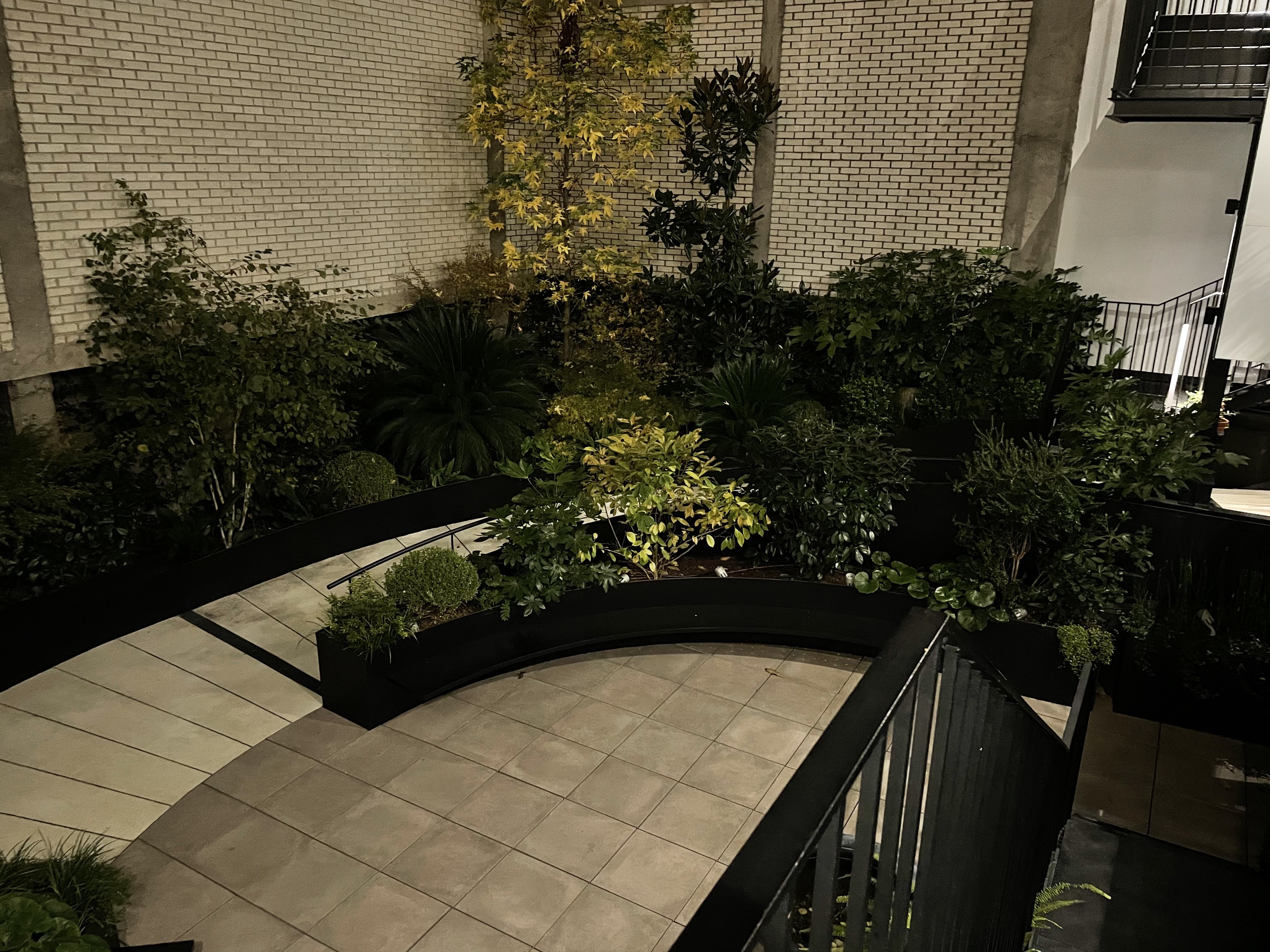 a patio with plants and a railing