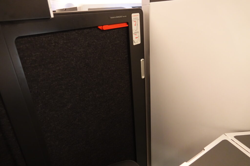 a black and white cubicle with a red handle