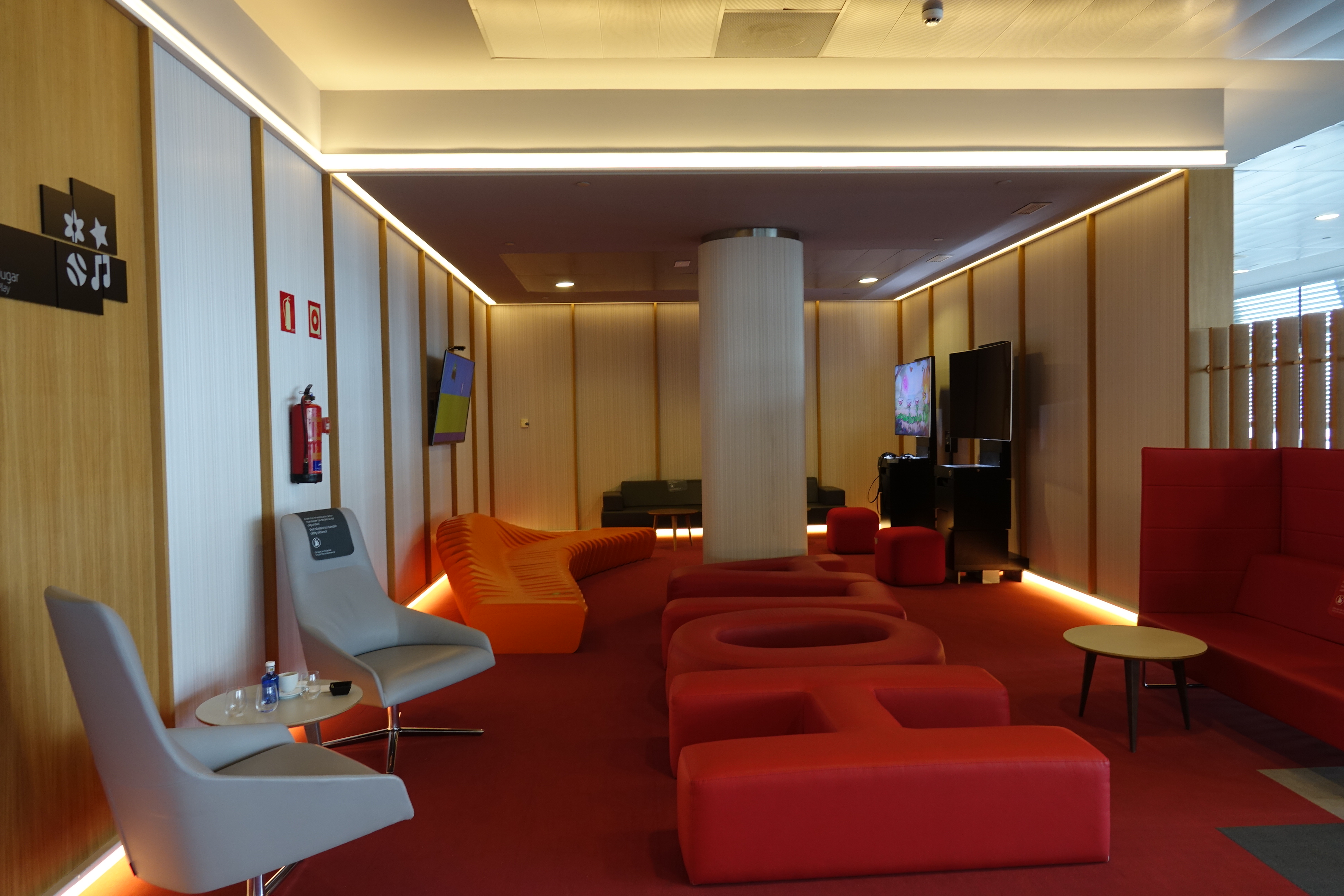 a room with red couches and a column