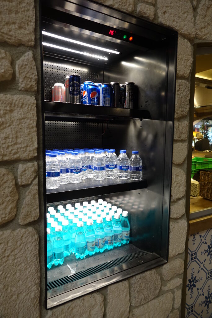 a shelf with bottles and cans of soda