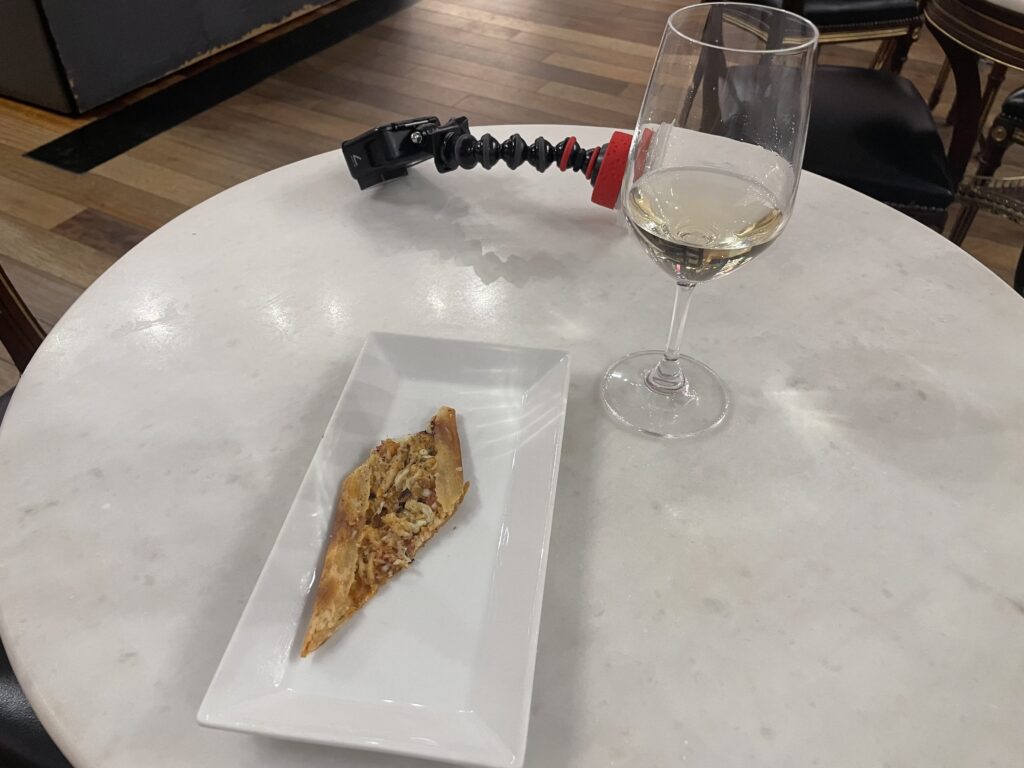 a plate of pizza and a glass of wine on a table