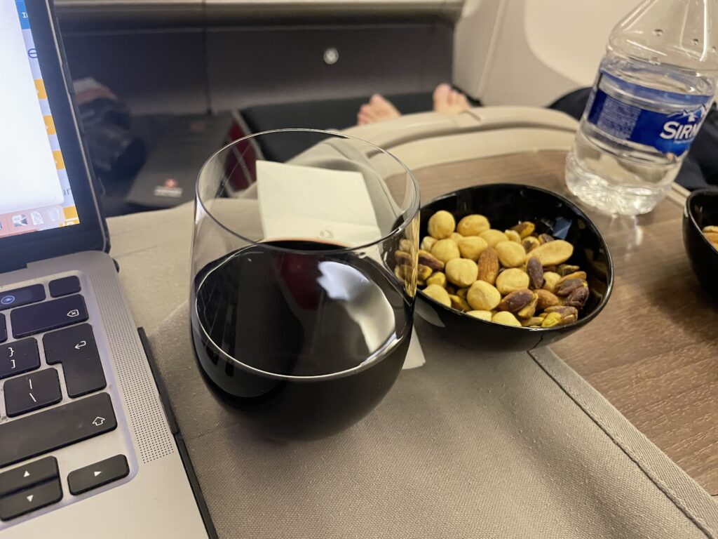 a bowl of nuts and a glass of wine on a table