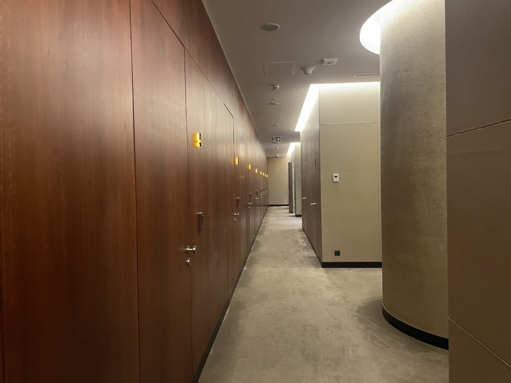 a hallway with wooden cabinets and a column