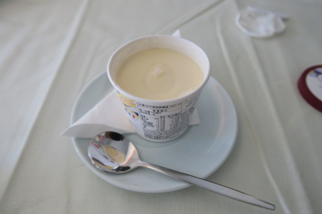a cup of food on a plate with a spoon