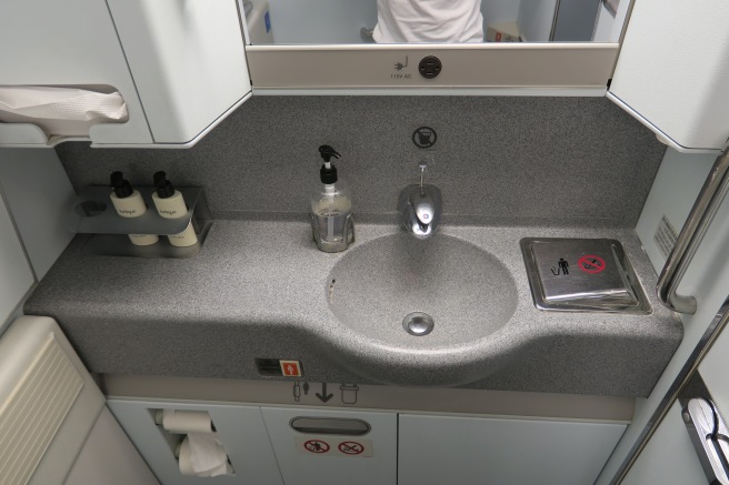 a sink with soap dispensers and a mirror