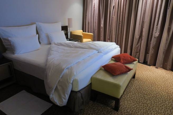 a bed with pillows and a bench in a hotel room