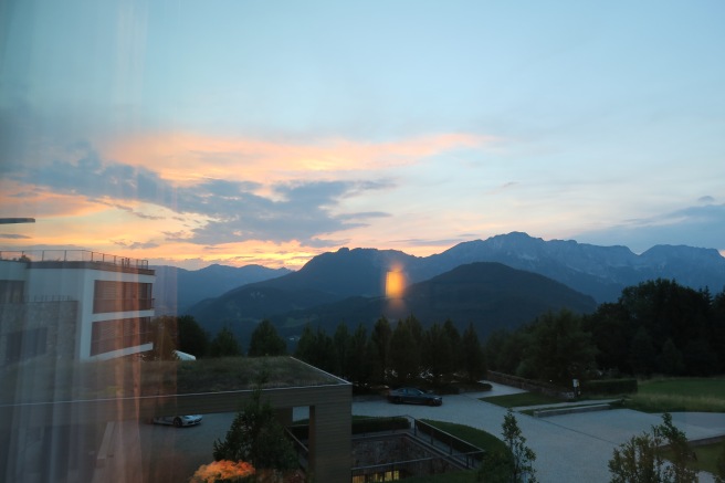 a view of mountains and a parking lot from a window
