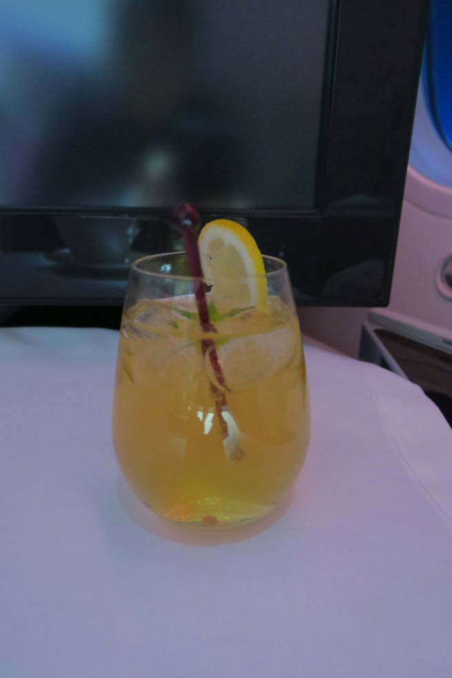 a glass with a drink and a straw in front of a television