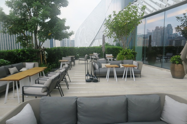 a patio with a glass wall and a glass wall and a building with a city view