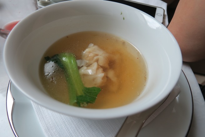 a bowl of soup with broth and a piece of food