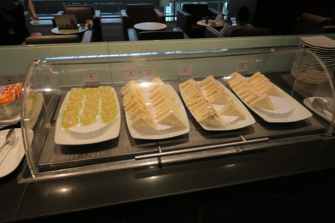 a trays of sandwiches and other food on a counter