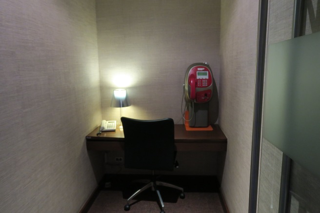 a desk with a phone and a lamp