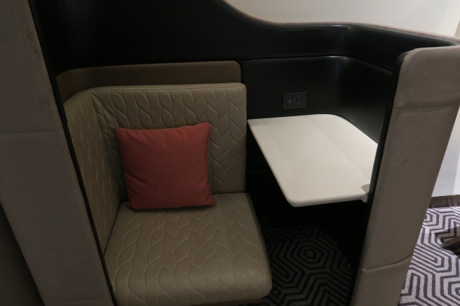 a seat with a pillow and a table