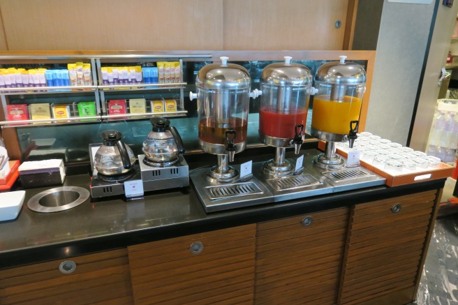 a group of juice dispensers on a counter