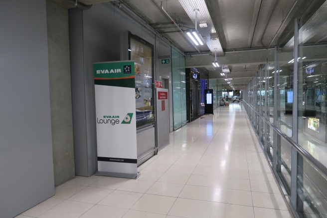 a long hallway with glass walls and a sign