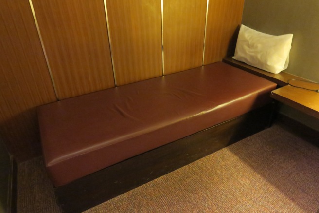 a brown cushioned bench in a room