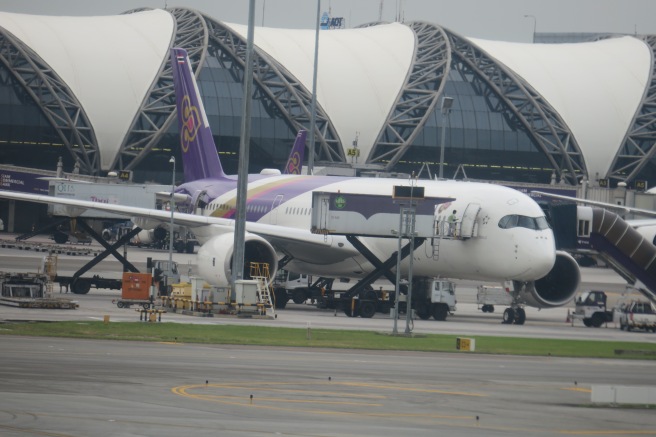 a large white and purple airplane on a runway