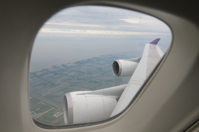 an airplane wing with a view of the land and the sky