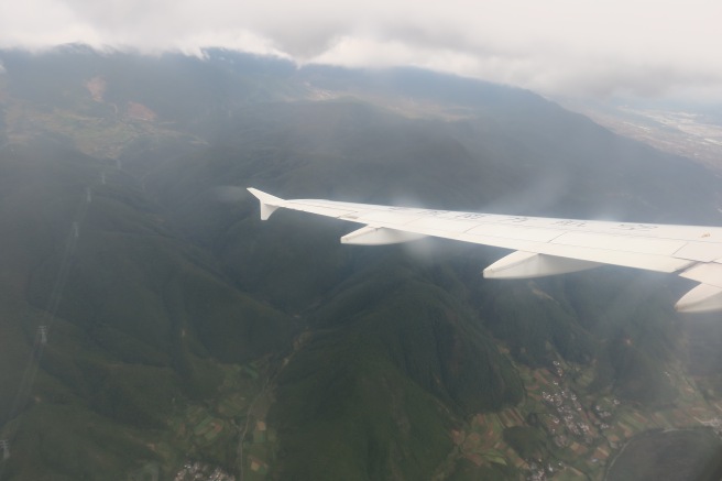 an airplane wing above a valley