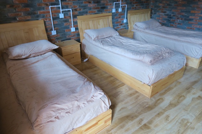a room with wooden beds and brick walls