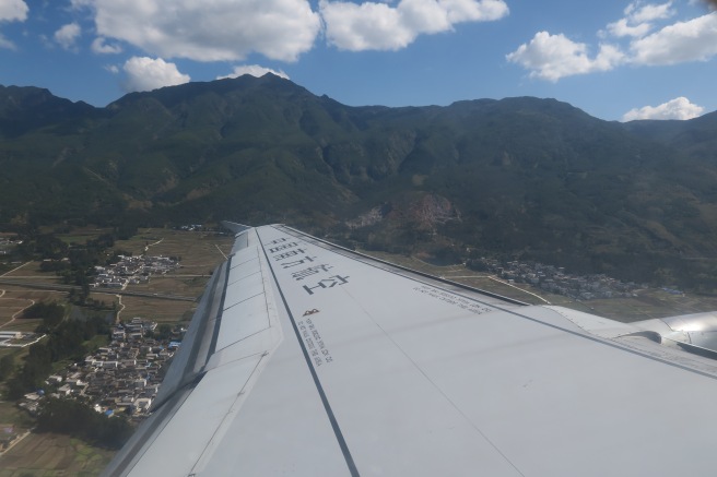 a wing of an airplane flying over a mountain