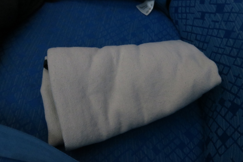 a white blanket on a blue seat