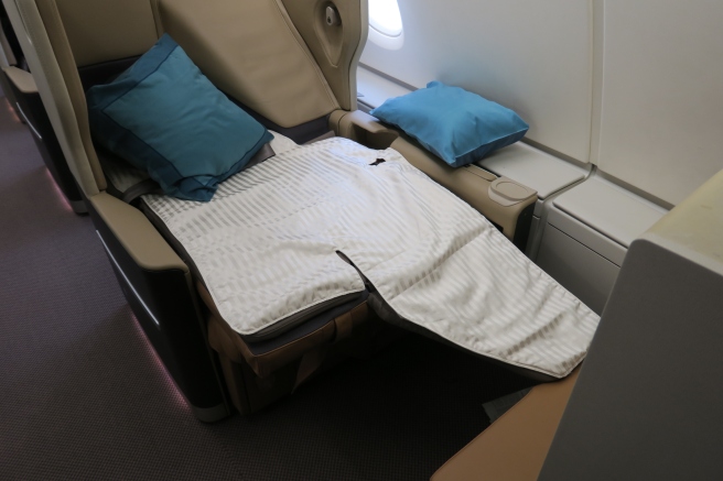 a seat with pillows and a blanket on it