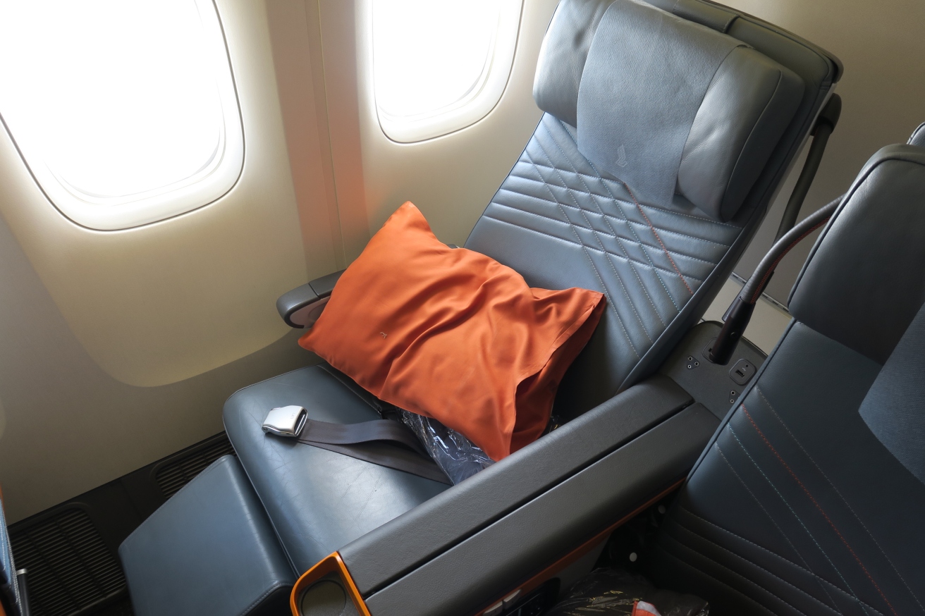 a seat with an orange pillow on it