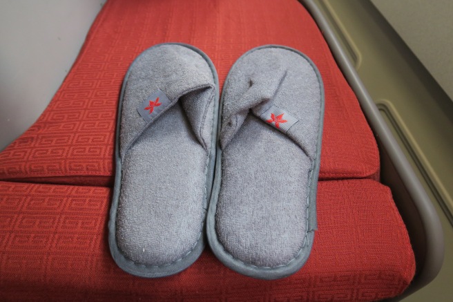 a pair of slippers on a red cushion