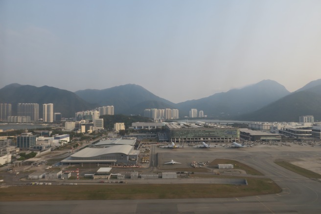 an airport with buildings and mountains in the background