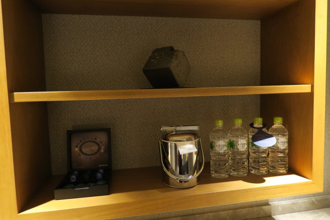a shelf with water bottles and a toaster