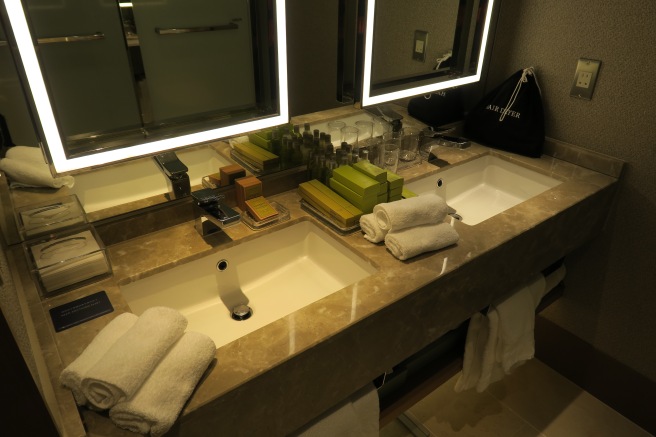 a bathroom sink with towels and a mirror