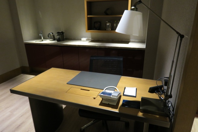 a desk with a lamp and a phone on it