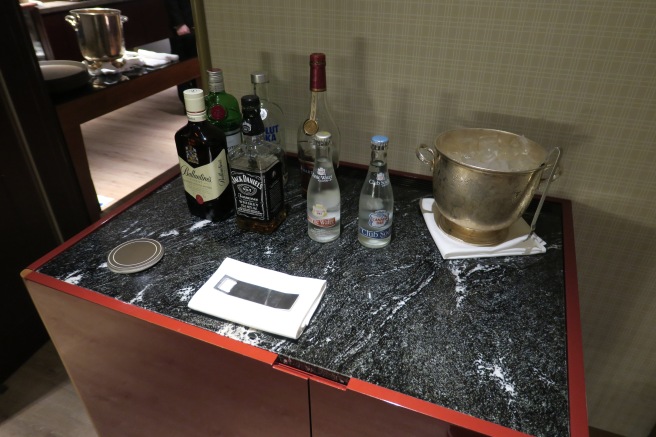 a counter top with bottles of alcohol and a bucket