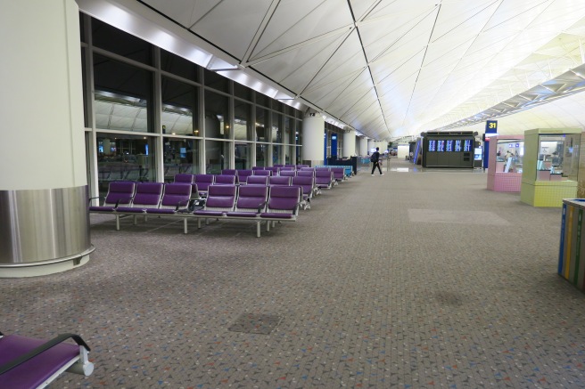 a row of purple chairs in an airport