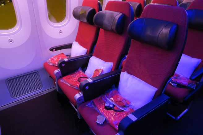 a row of red seats in a plane