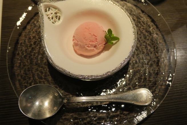 a bowl of ice cream with a leaf on top of it