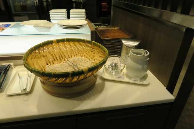 a basket of noodles and a pitcher of sugar on a table