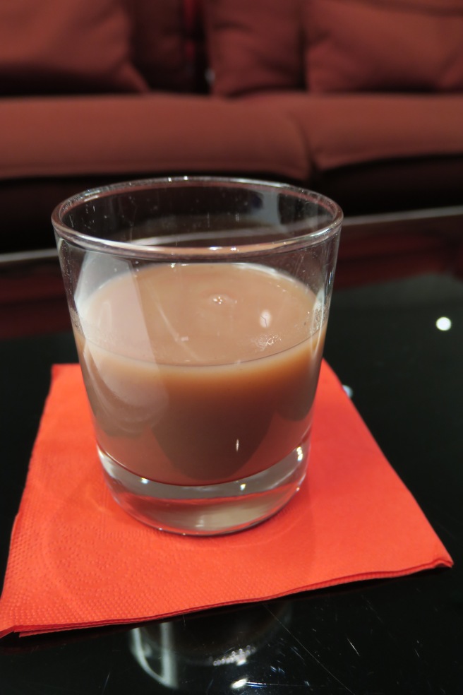 a glass of brown liquid on a napkin
