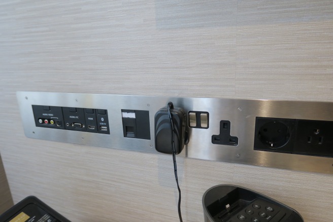 a wall with a power outlet and plugs