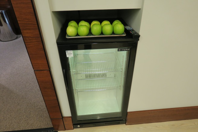 a group of green apples on top of a refrigerator
