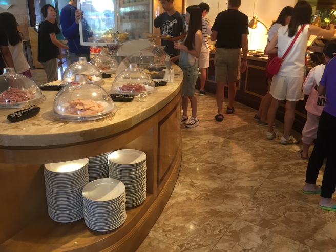 a group of people standing around a buffet