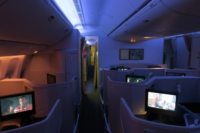 a room with rows of seats and televisions